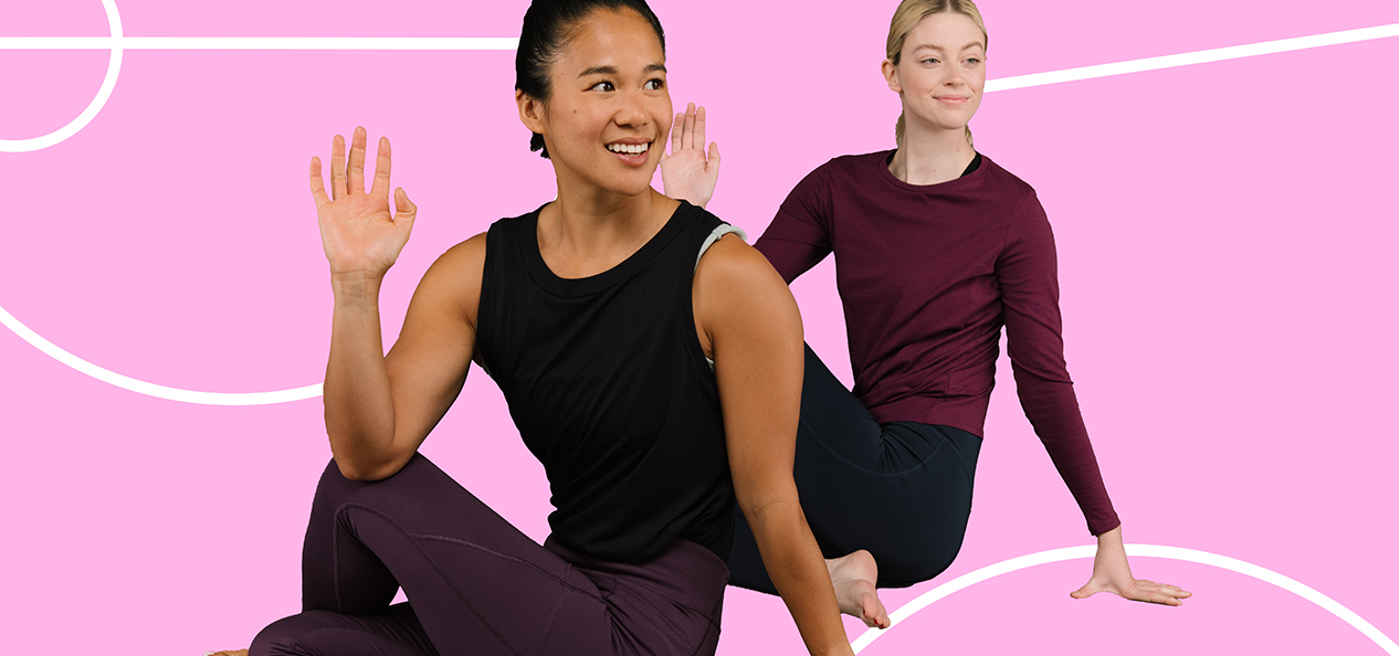 Two Studio You instructors stretch in front of a pink backdrop