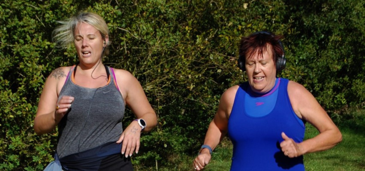Alison running outside with her friend. 