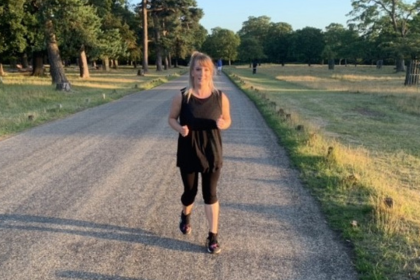 Rebecca wearing black running gear, running outside in the park. 