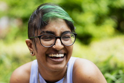 Zeenat smiling outside in the park.