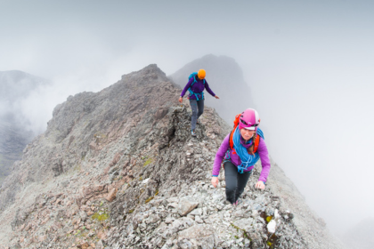Two women walking on a mountain.