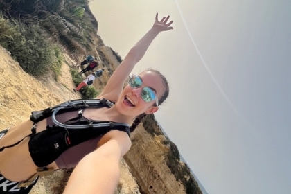 Eleana takes a selfie on a run with arms in the air