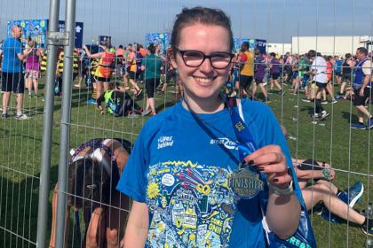 Woman showing her medal after a race 