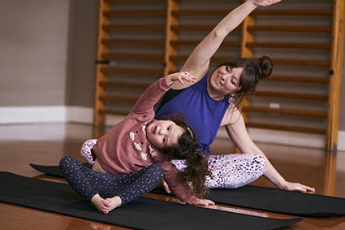 A mother and daughter do yoga together