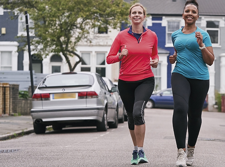 Two women run on a road