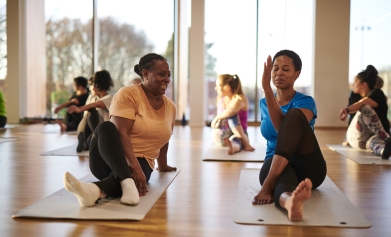 A group of women stretch in an exercise class