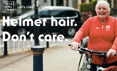 A Breeze leader poses on a poster saying 'helmet hair, don't care'